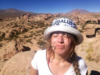 Portrait of young woman with mountains in background