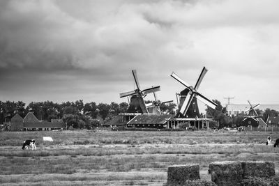 Traditional windmill on field against sky