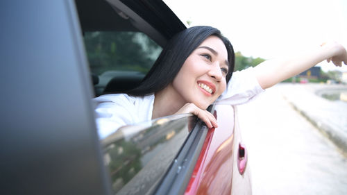 Portrait of happy young woman in car