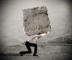 Side view of man standing against wall