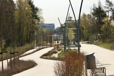Road by buildings in city against sky