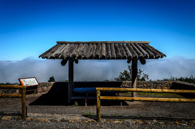 Built structure on field against blue sky