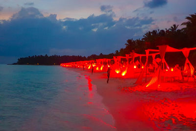 Scenic view of beach against sky at dusk