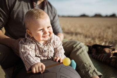 Cute baby boy sitting at toy