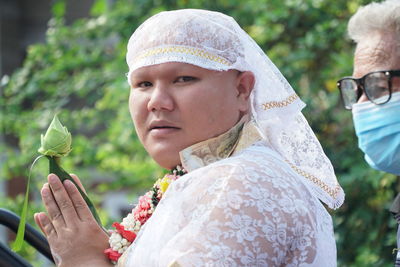 Portrait of woman holding camera outdoors