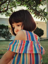 Portrait of young woman standing against trees