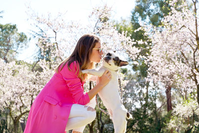 Side view of woman kissing dog