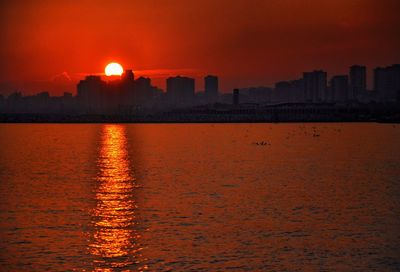 Scenic view of lake against orange sky