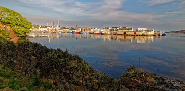 Scenic view of sea by buildings against sky