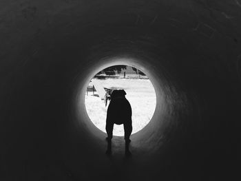 Silhouette woman standing in tunnel