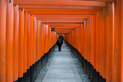 Rear view of man walking in corridor of building