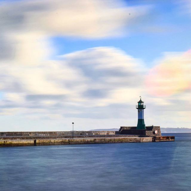 architecture, lighthouse, waterfront, built structure, water, sky, sea, building exterior, cloud - sky, guidance, cloudy, cloud, direction, tower, tranquility, tranquil scene, scenics, rippled, nature, protection