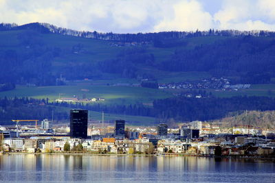 Scenic view of lake by buildings against sky