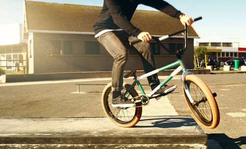 Low section of man riding bicycle on street