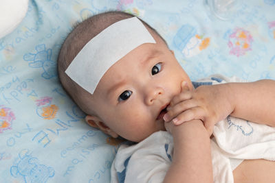 Portrait of cute baby lying on bed