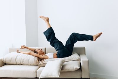 Low section of woman exercising against wall