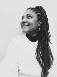 Portrait of smiling young woman against wall