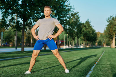 Full length of woman exercising on field