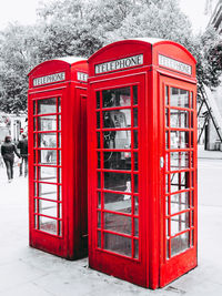 Red telephone booth on street in winter