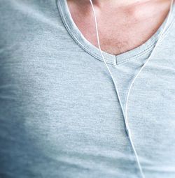Midsection of man with headphones wearing t-shirt