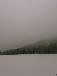 Scenic view of snow covered land against sky