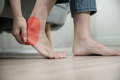 Low section of woman standing on hardwood floor