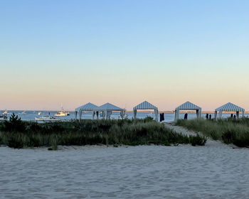 Houses on beach by sea against clear sky