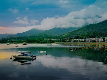 Boats in lake against mountain range
