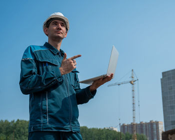 Portrait of man standing against sky