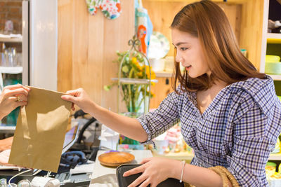 Young woman buying food at restaurant