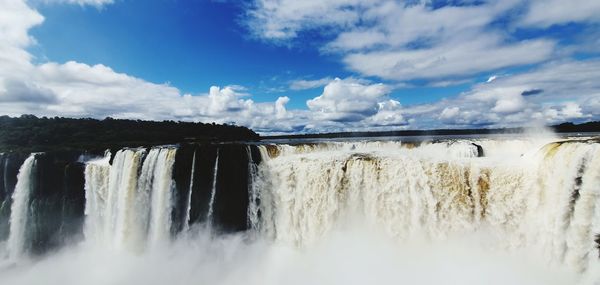 Scenic view of waterfall against sky