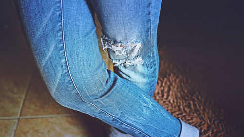 Midsection of person wearing torn jeans