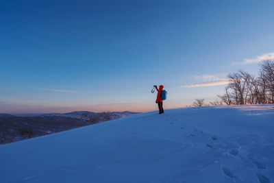 Man on snow field against blue sky