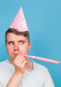 Portrait of man holding blue against gray background