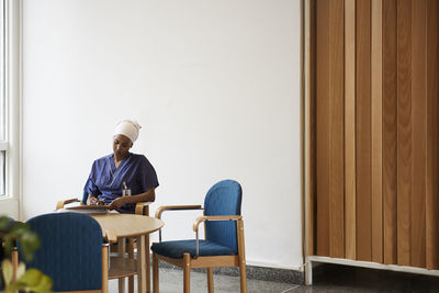 Female doctor sitting at table and taking notes