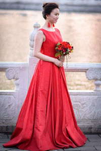 Full length of woman standing by red flower