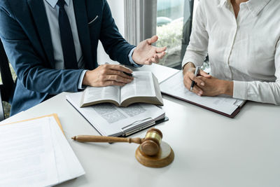 Midsection of business colleagues working on table