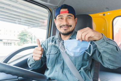 Portrait of smiling man sitting in car