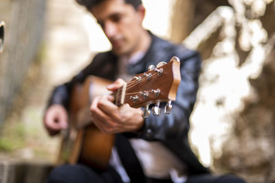 Midsection of man playing guitar