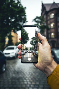 Midsection of person using mobile phone in city