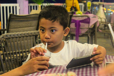 Close-up portrait of boy holding tea in restaurant