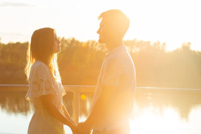 Couple embracing while standing by lake