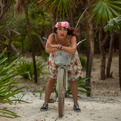 Portrait of young woman standing against trees