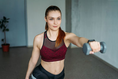 Young woman lifting dumbbell