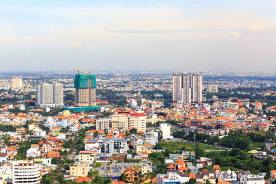 High angle view of buildings in city against cloudy sky