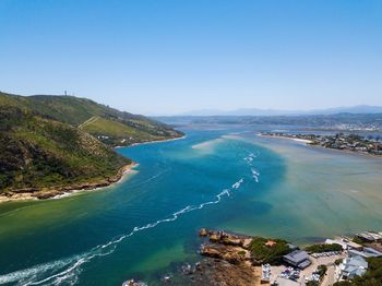 Scenic view of bay against clear blue sky