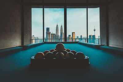 Balls arranged on pool table against window