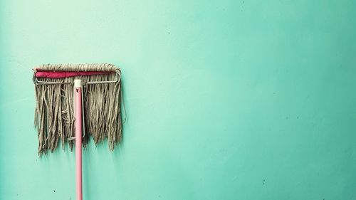 Close-up of mop on green wall