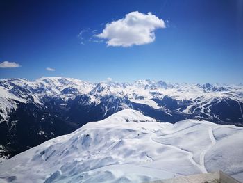 Scenic view of snowcapped mountains against blue sky