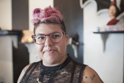 A portrait of a young woman with pink hair.